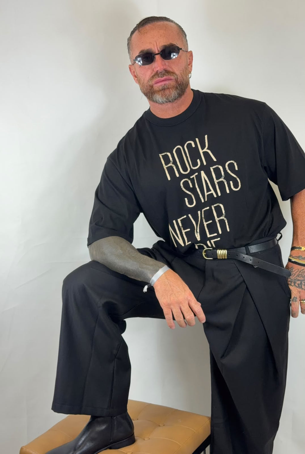 T-shirt oversize nera con stampa Rock Stars Never Die, look seduto