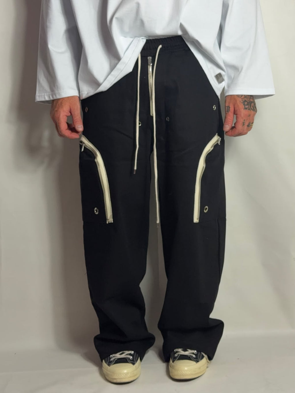 Pantalone Rick nero indossato con maglia bianca e sneakers