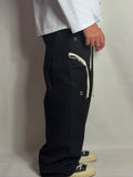 Pantalone Rick nero indossato, con zip a contrasto e coulisse